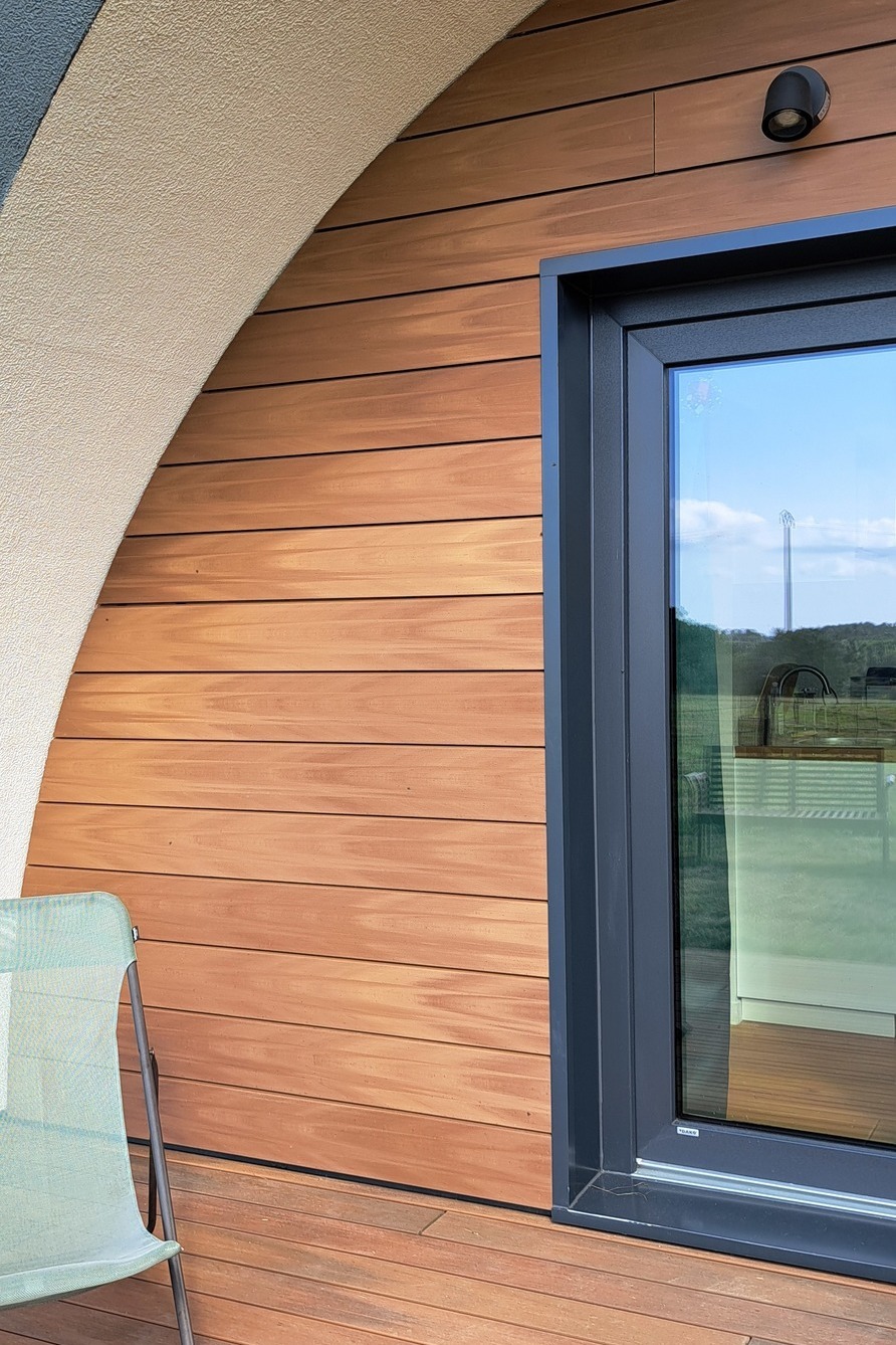 Silvadec composiet houten gevelbekleding met horizontale latten op een modern huis, met nadruk op het contrast tussen composiet hout en antracietkleurige aluminium raamkozijnen