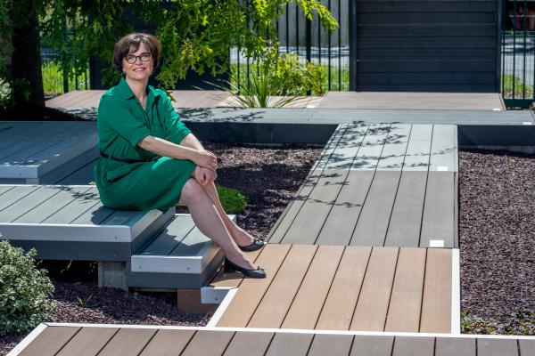 photo de la dirigeante et fondatrice de Silvadec assise sur des lames de terrasse